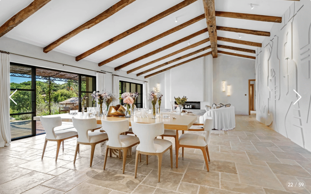 Spacieuse salle à manger avec grande table, poutres apparentes et accès direct à la terrasse vue mer