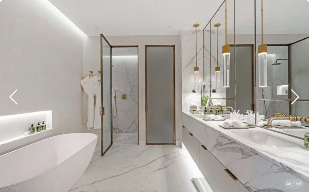 Luxueuse salle de bain ouverte avec baignoire et vasque design dans la suite de la Villa l'Olivier