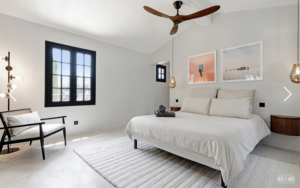 Chambre minimaliste avec lit double, ventilateur et accès au jardin