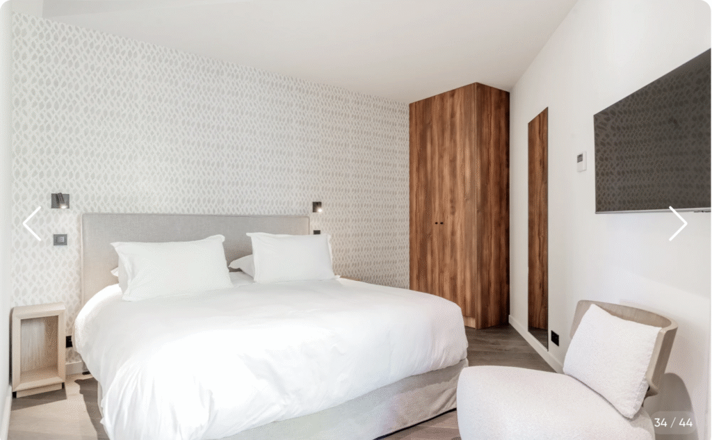 Lit double confortable dans une chambre spacieuse avec tête de lit capitonnée de la villa de luxe