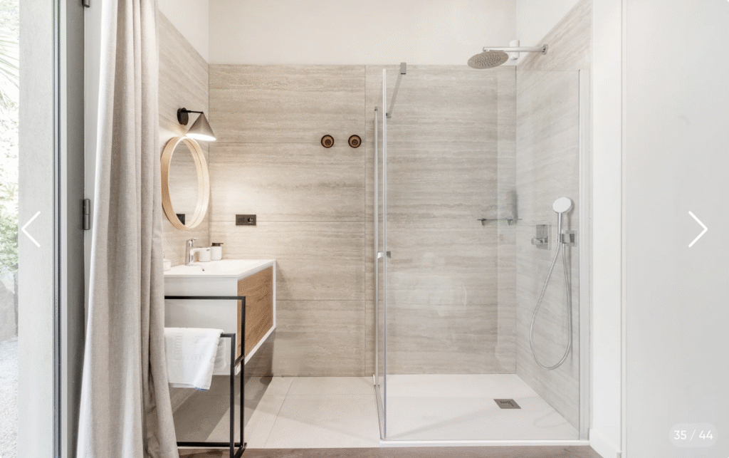 Douche à l'italienne et carrelage moderne dans une des salles de bain élégantes de la Villa Loum