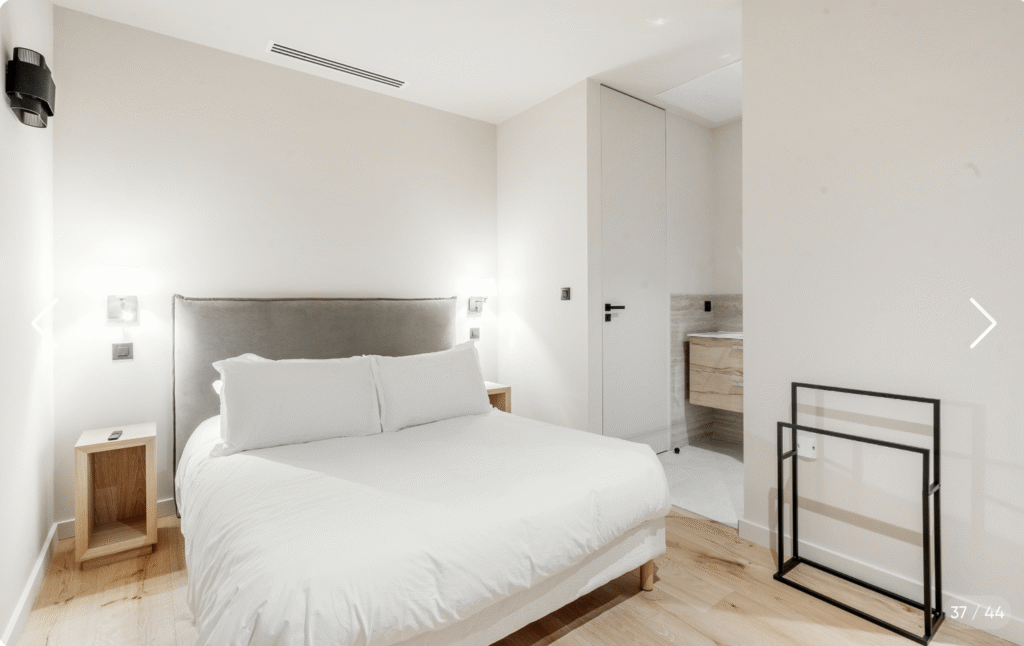 Chambre double design avec éclairage indirect et linge de maison premium, idéale pour le repos