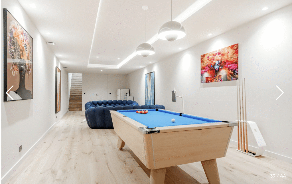 Espace de loisirs avec billard américain, canapé confortable et télévision, idéal pour les soirées