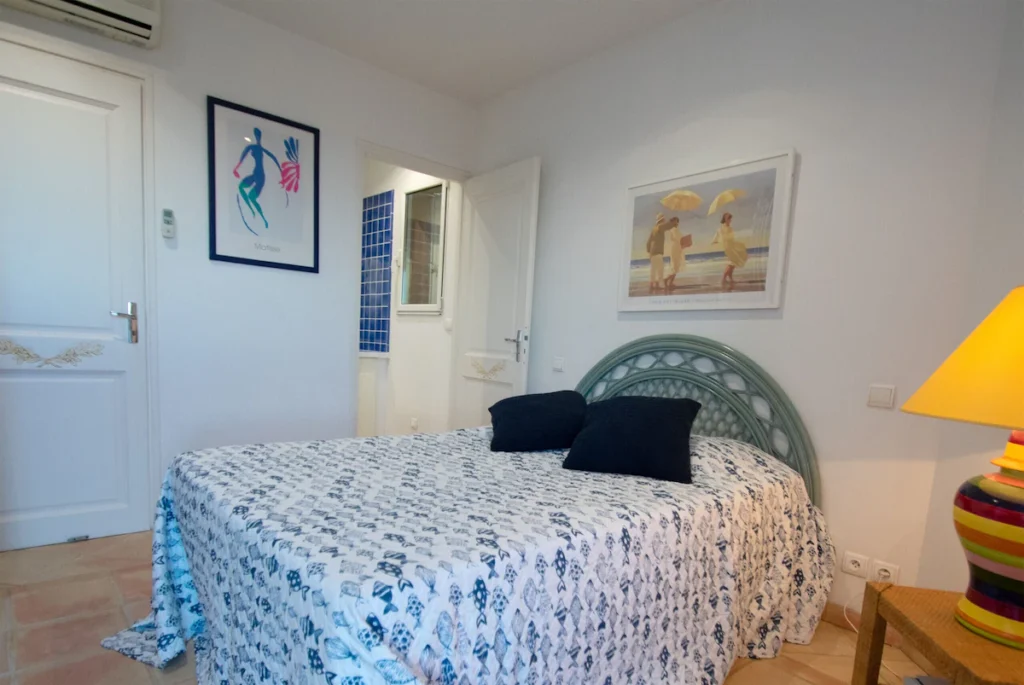 Chambre cosy aux textures chaleureuses avec couette colorée, lampes d’ambiance et éléments décoratifs artisanaux.