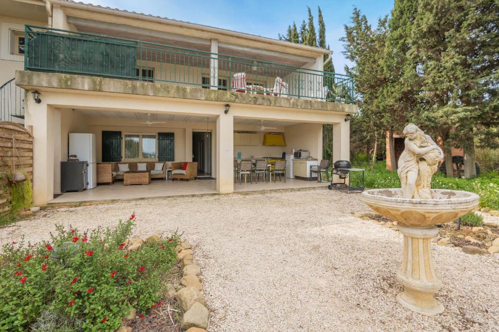 Villa avec grande terrasse couverte, jardin et statue décorative à Sainte-Maxime